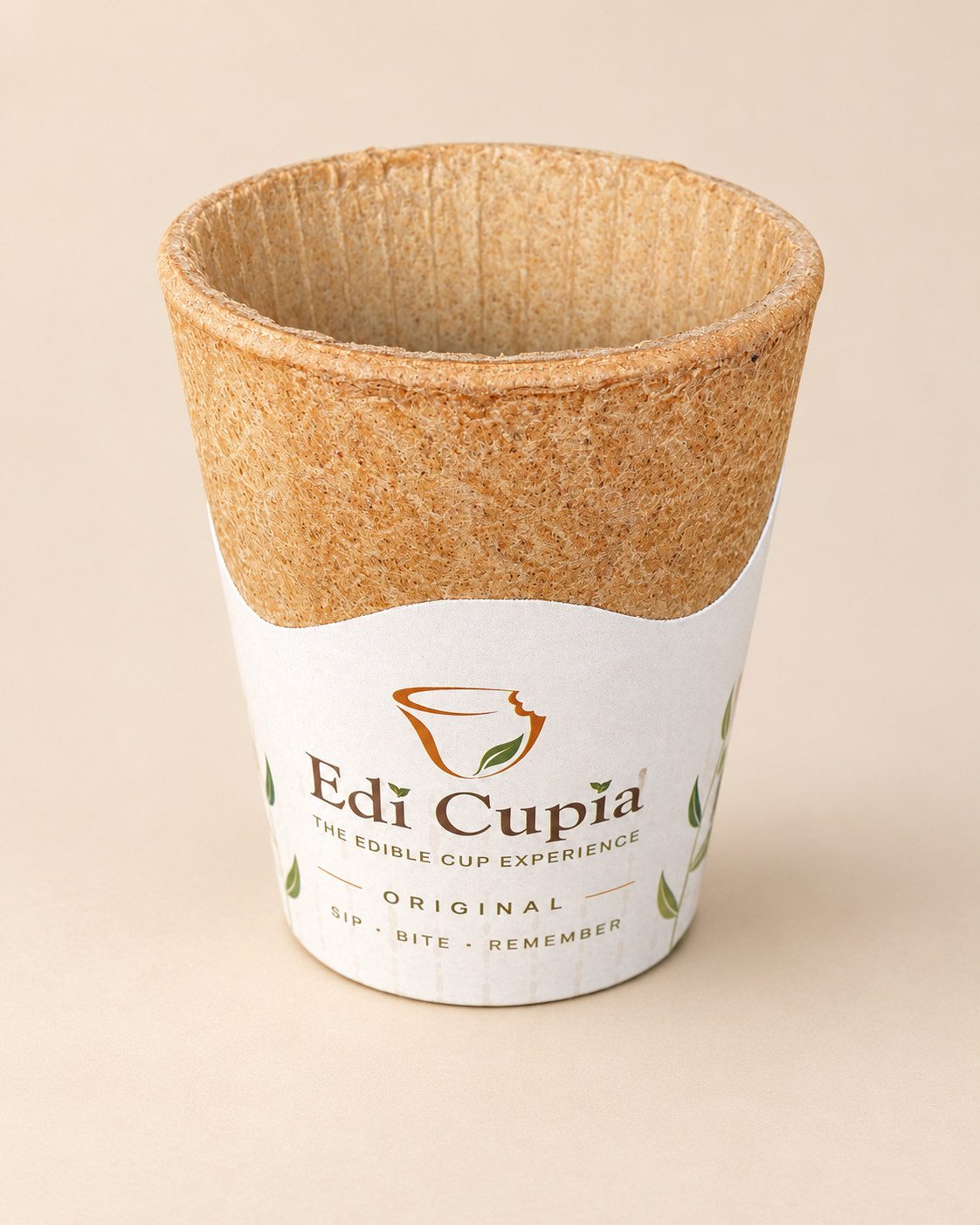 Une tasse comestible en gaufrette Edi Cupia Original, vide, vue de trois quarts en plongée, son épais rebord cuit et ses fines nervures intérieures bien visibles.
