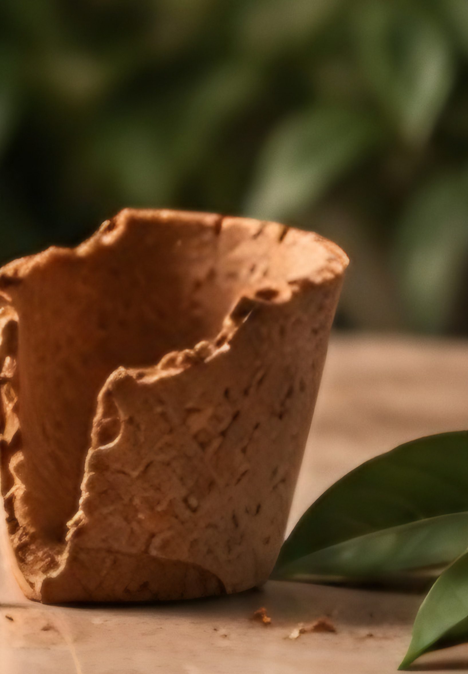 A half-eaten edible cup resting on a wooden table with a few crumbs.
